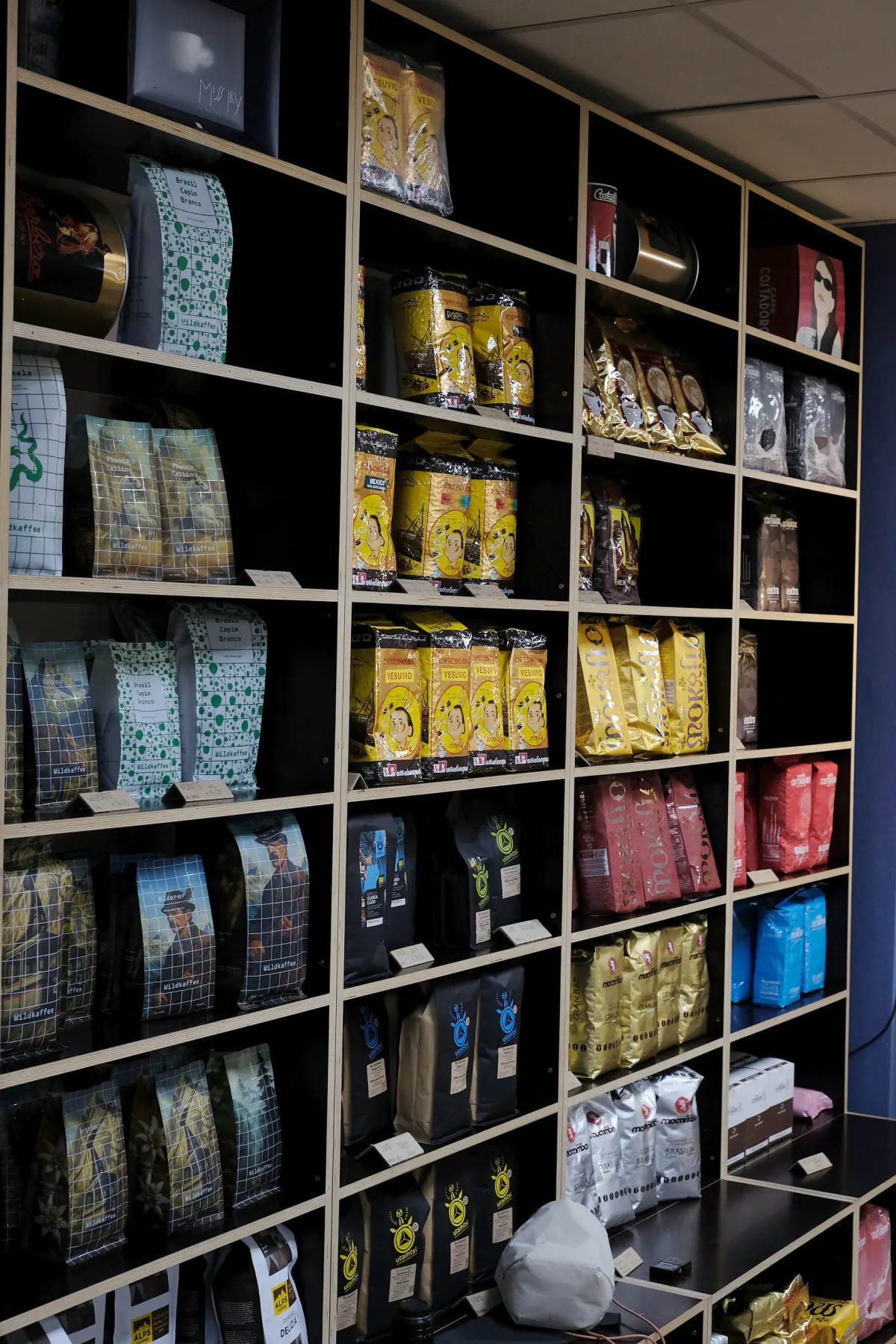 Hohes Regal voller Kaffeesorten im Laden
