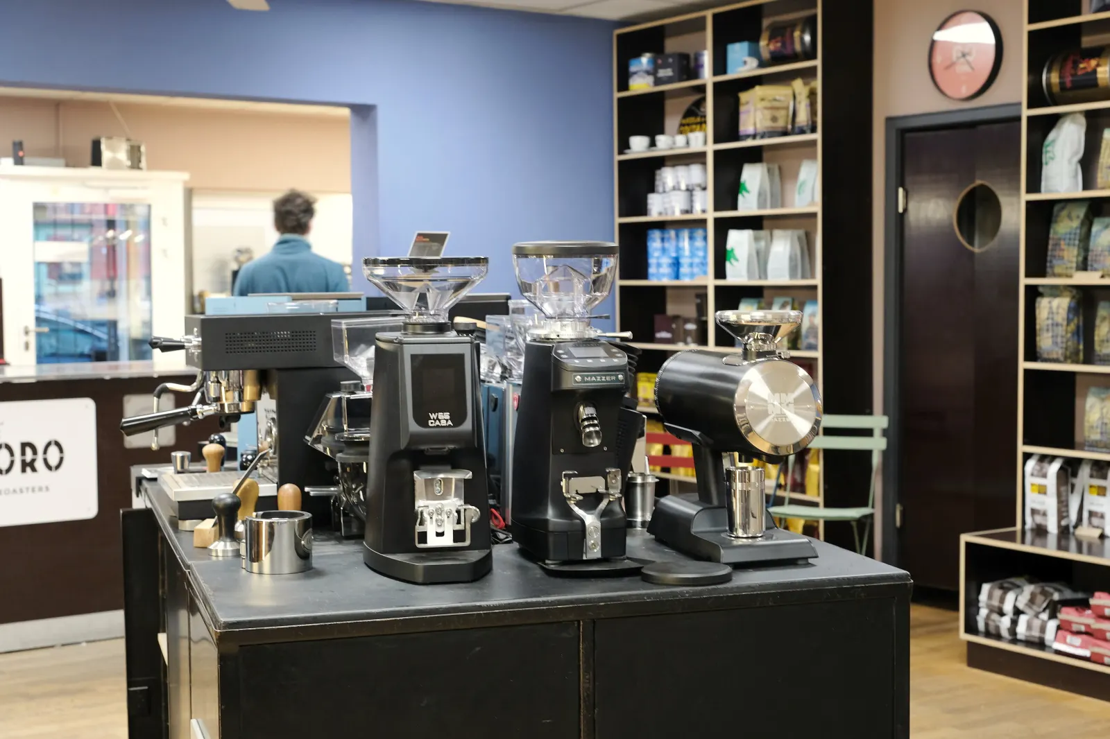 Mühlen-Insel mit Espressomühlen vor dem Kaffeeregal