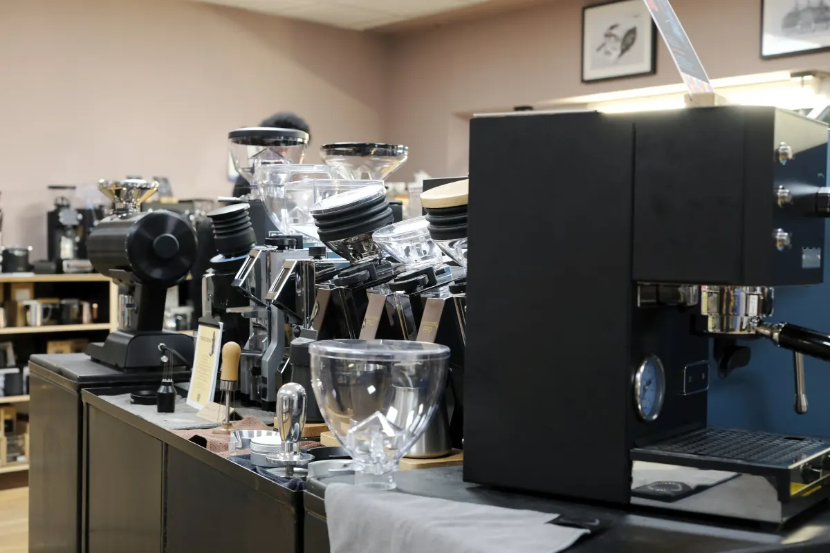 Reihe von Espressomühlen und eine Siebträgermaschine im Laden