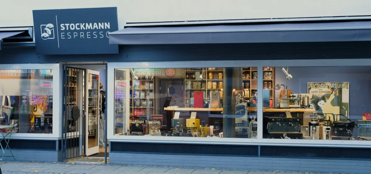 Ladenfront von Stockmann Espresso am Richtweg mit Schild, offener Tür und Schaufenster voller Maschinen und Kaffee